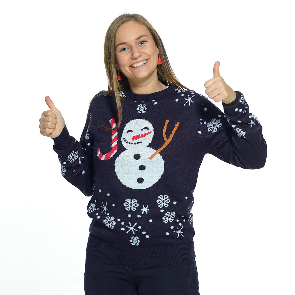 Una donna che indossa un maglione natalizio blu con un pupazzo di neve e fiocchi di neve.